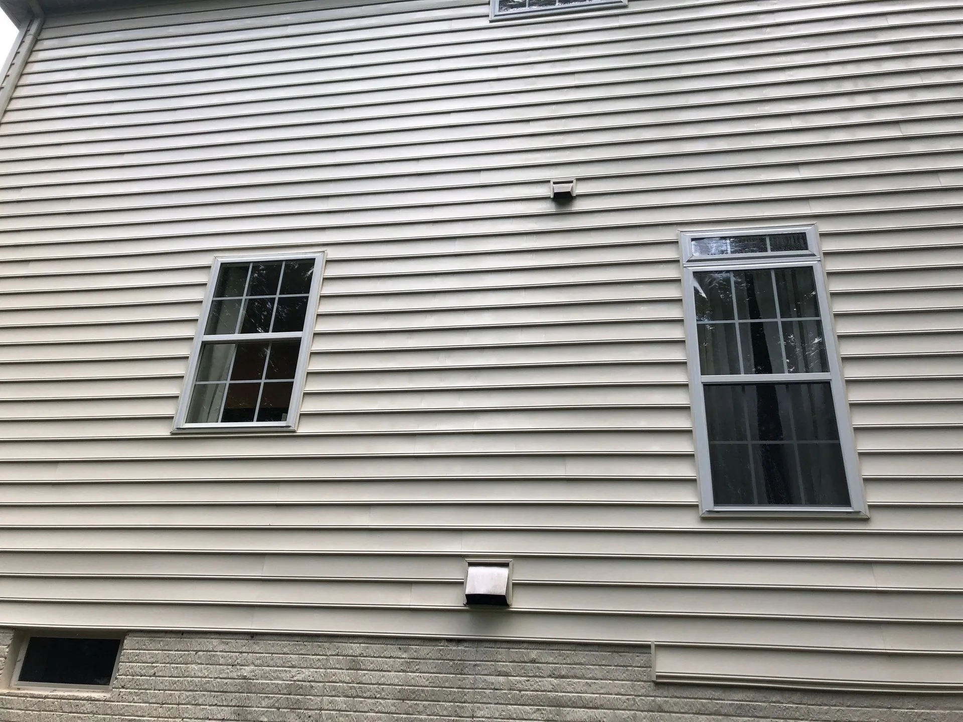 Same clapboard siding fully cleaned after soft wash treatment