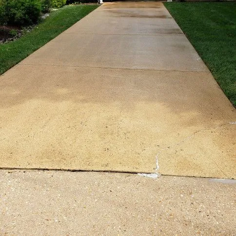 Exposed-aggregate driveway in warm tone after pressure washing